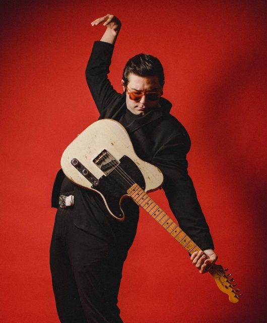 Eddie 9V with guitar and red backdrop