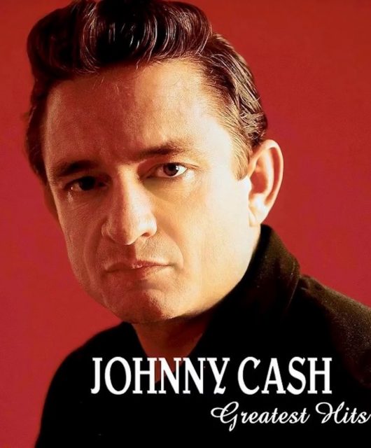 Johnny Cash looks at the camera in front of a red background